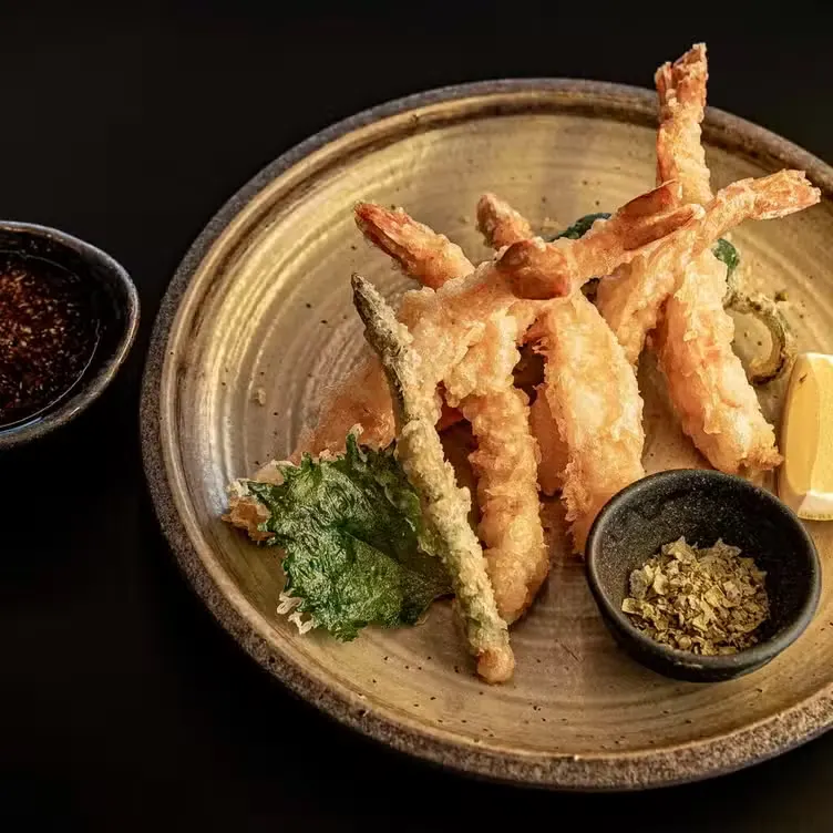 Crisp shrimp tempura plated with dipping sauce