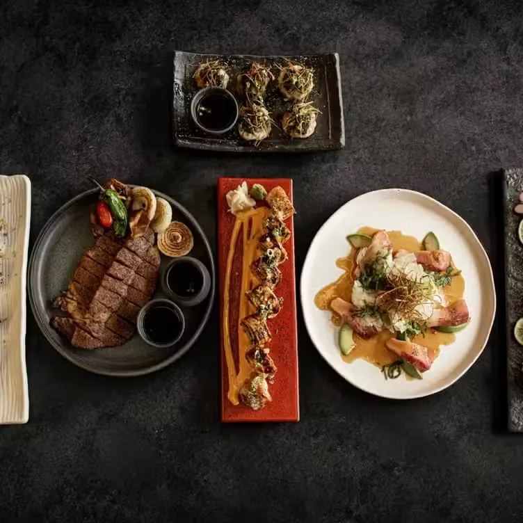 Steak, rolls and small plates arranged for sharing