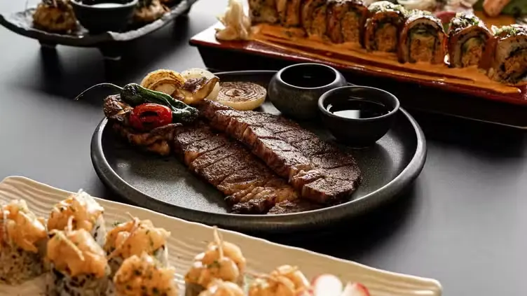 A shared table of steak, rolls and small plates
