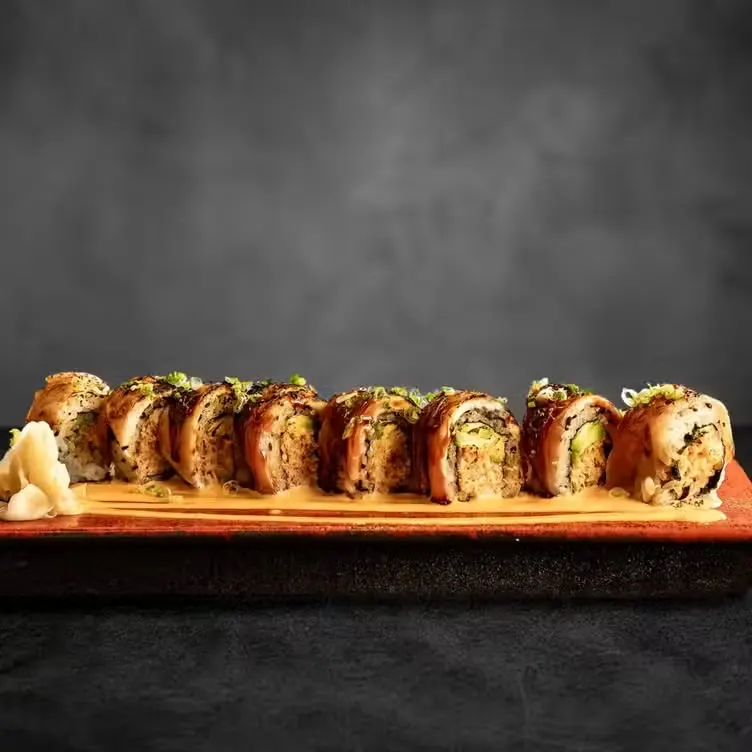 A dragon roll topped with avocado and eel sauce